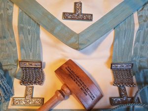 Bro. John Michael Reynolds was invested with the same apron his uncle R.W. Bro. J. David Innes had been invested with almost forty-five and a half years earlier on December 27th 1971. As R.W. Bro. Innes was D.D.G.M. for the Nickel Lodge Centennial Year, he didn't have a guilded apron. Photo shows the apron and gavel presented to W. Bro. J.M. Reynolds.